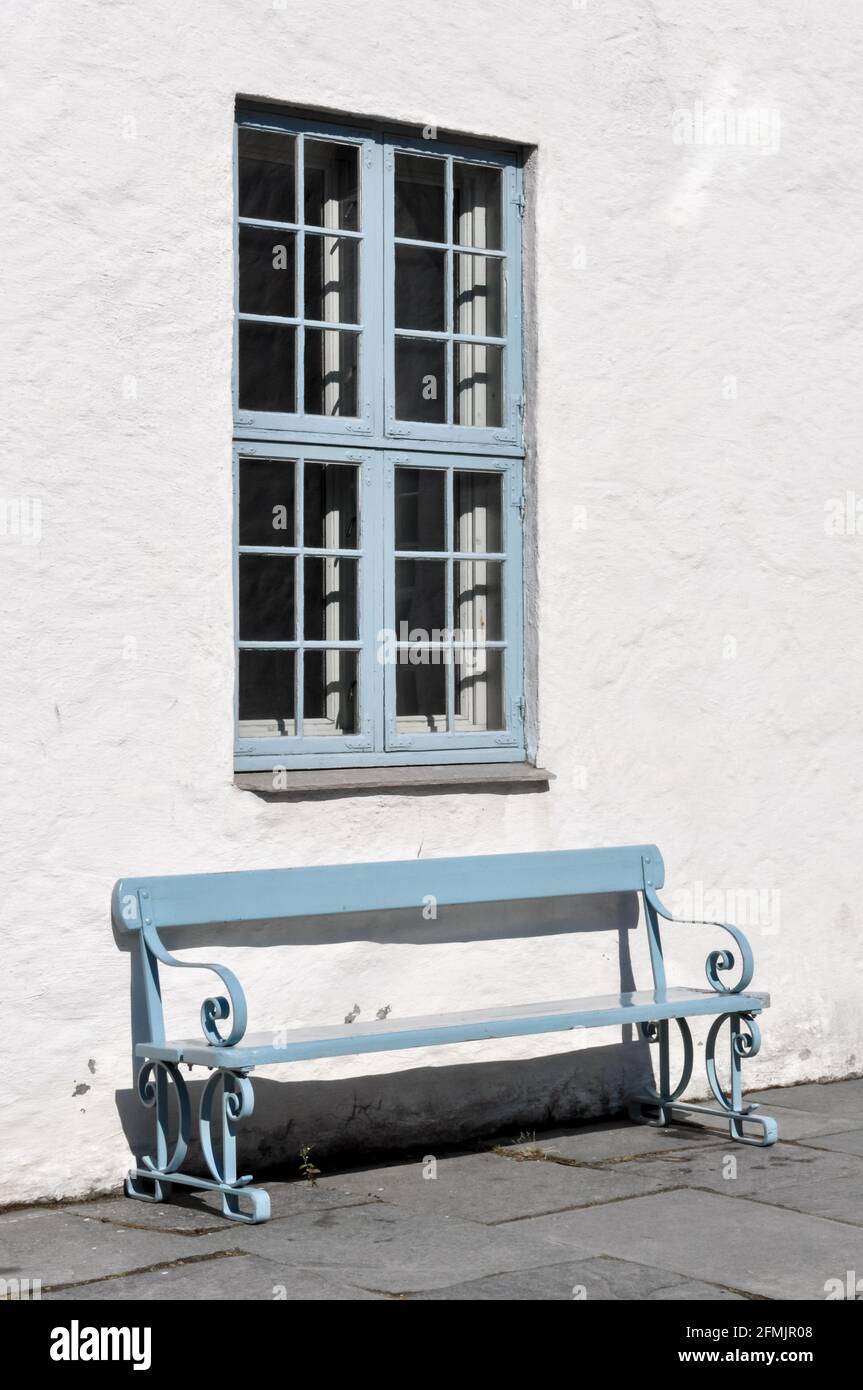 Blue bench against a white house Stock Photo
