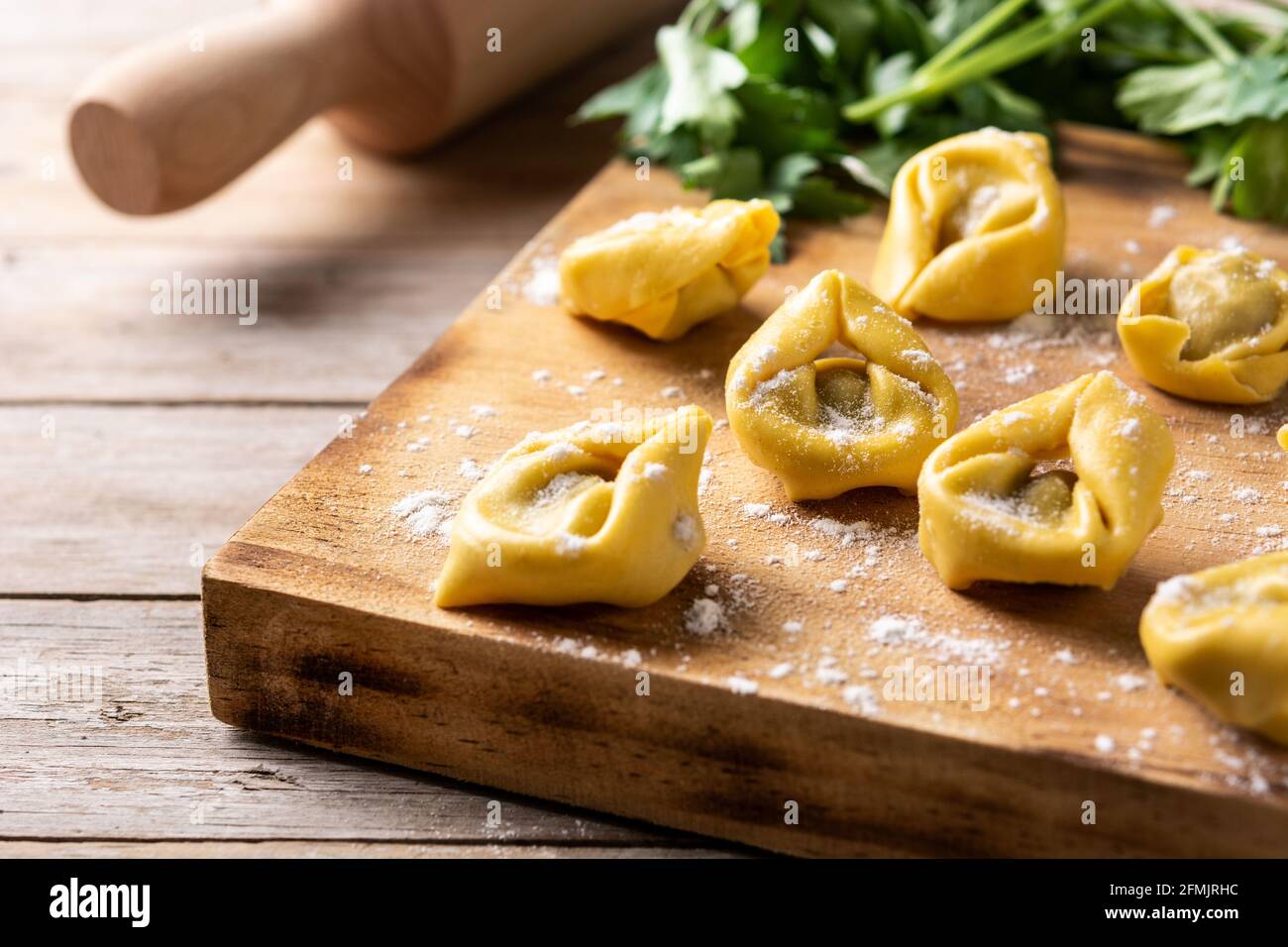 Uncooked pelmeni dumplings on wooden table Stock Photo