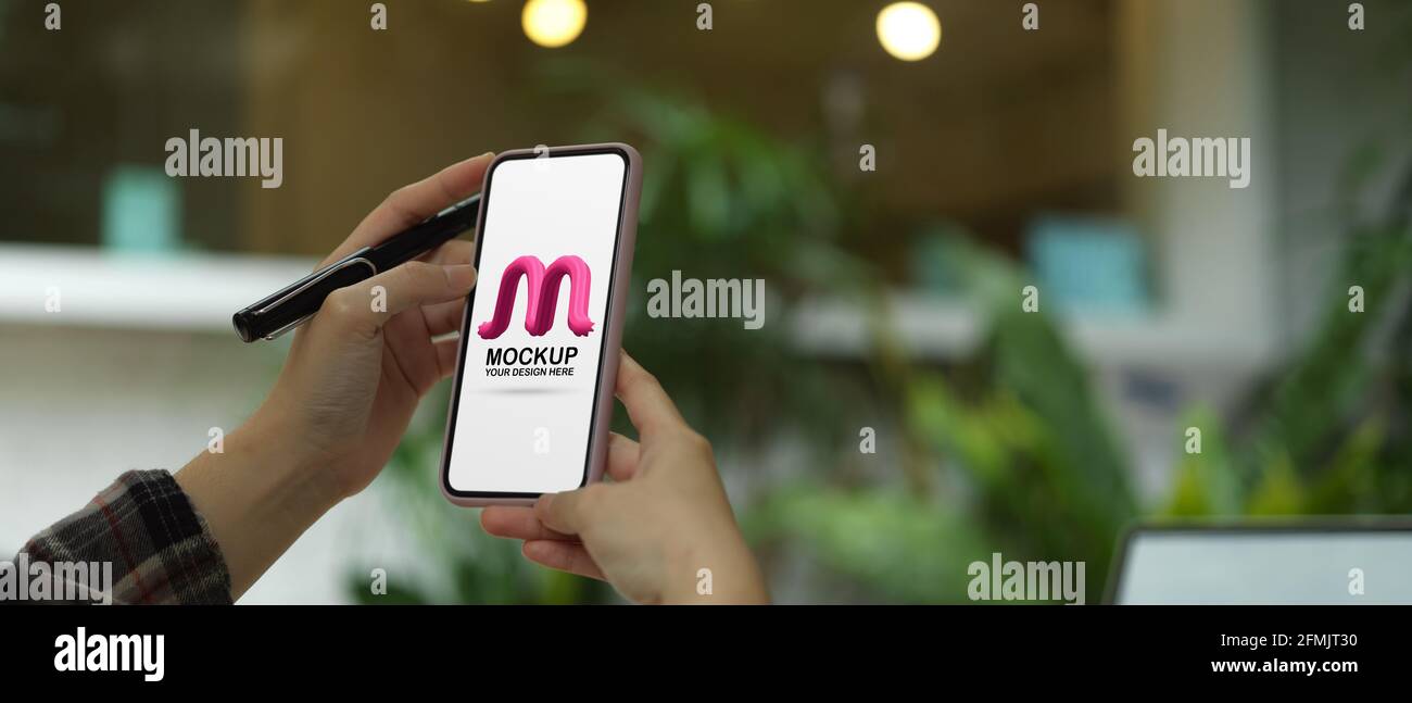 Close up view of female hands holding mock up smartphone with blurred ...