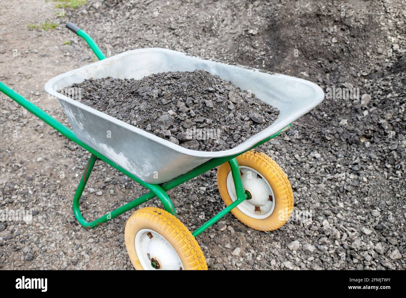 Hand wheelbarrow with gravel on the street. as part of a construction