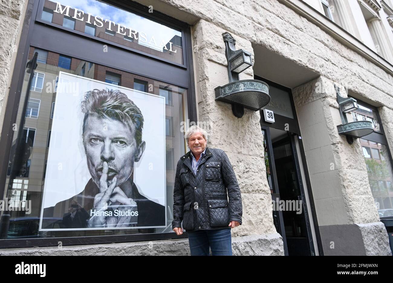 03 May 2021, Berlin: Singer Bernhard Brink stands by a photo of David Bowie  at the entrance to Hansa Studios during a walk. He auditioned here in the  70s and then signed