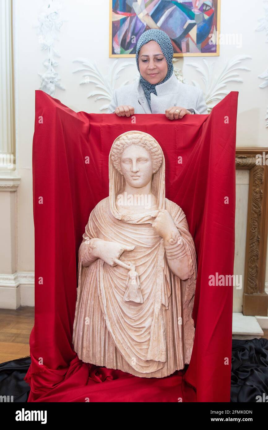 Lybian Embassy First Secretary Enas Kaal with the second century funerary statue depicting Demeter or Persephone at the Libyan Embassy, central London. The statue is being returned with help from the government, the Libyan Embassy and the British Museum after it was seized by HMRC when it was brought into the UK from Libya illegally by a dealer. Issue date: Monday May 10, 2021. Stock Photo
