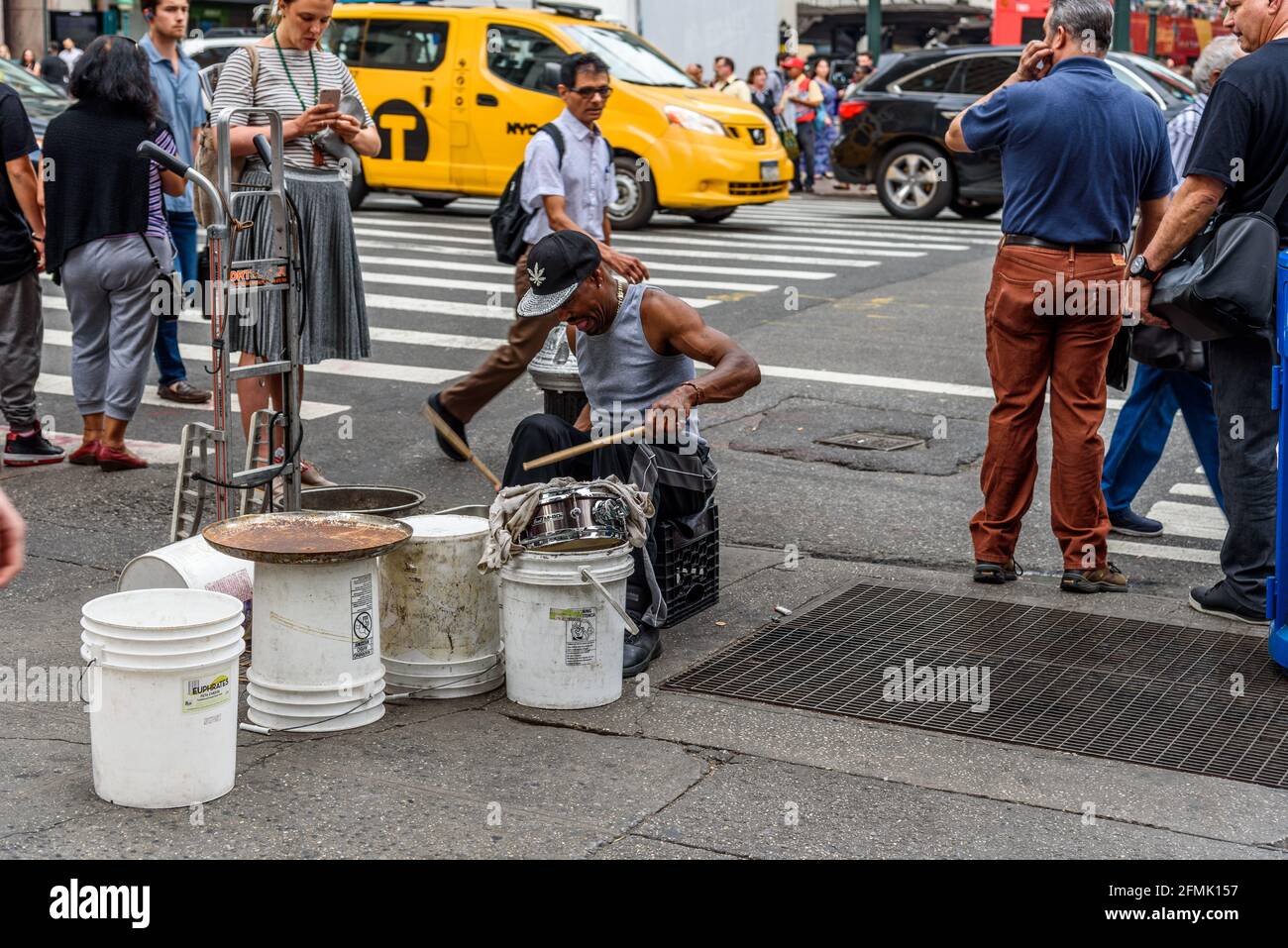 New York City, USA - June 22, 2018: Black man playing drums with plastic buckets in New York city street Stock Photo