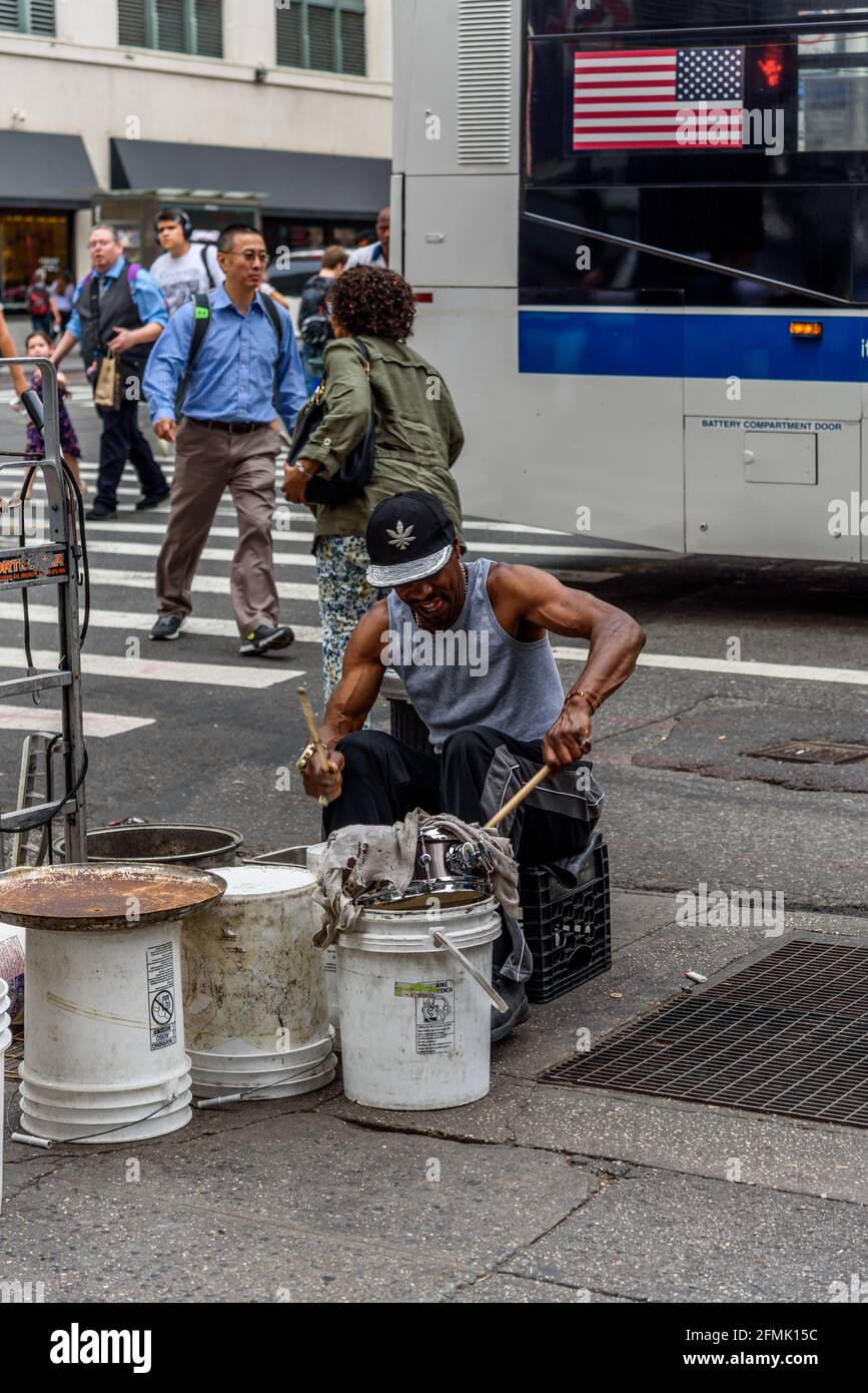 New York City, USA - June 22, 2018: Black man playing drums with plastic buckets in New York city street Stock Photo