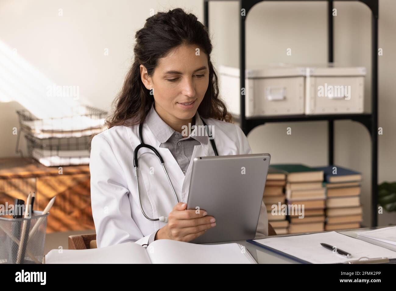 Young woman medical worker use pad study information on website Stock ...