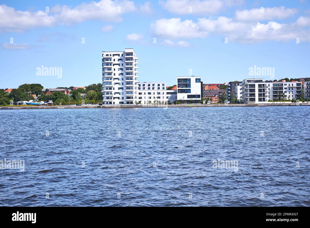 Image showcasing a modern condo building by the blue water Stock Photo - Alamy