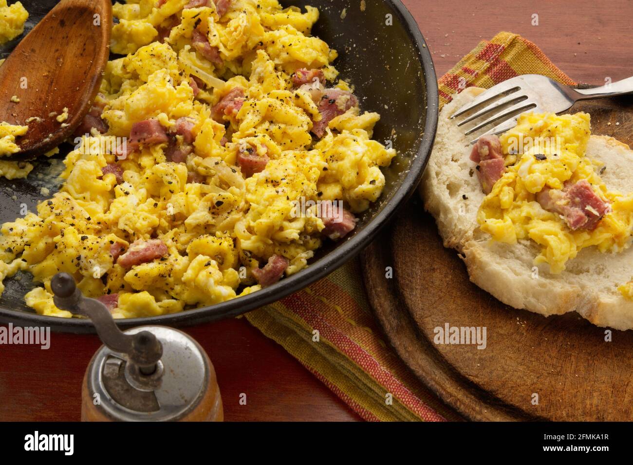 scrambled eggs and bacon in pan with bread Stock Photo