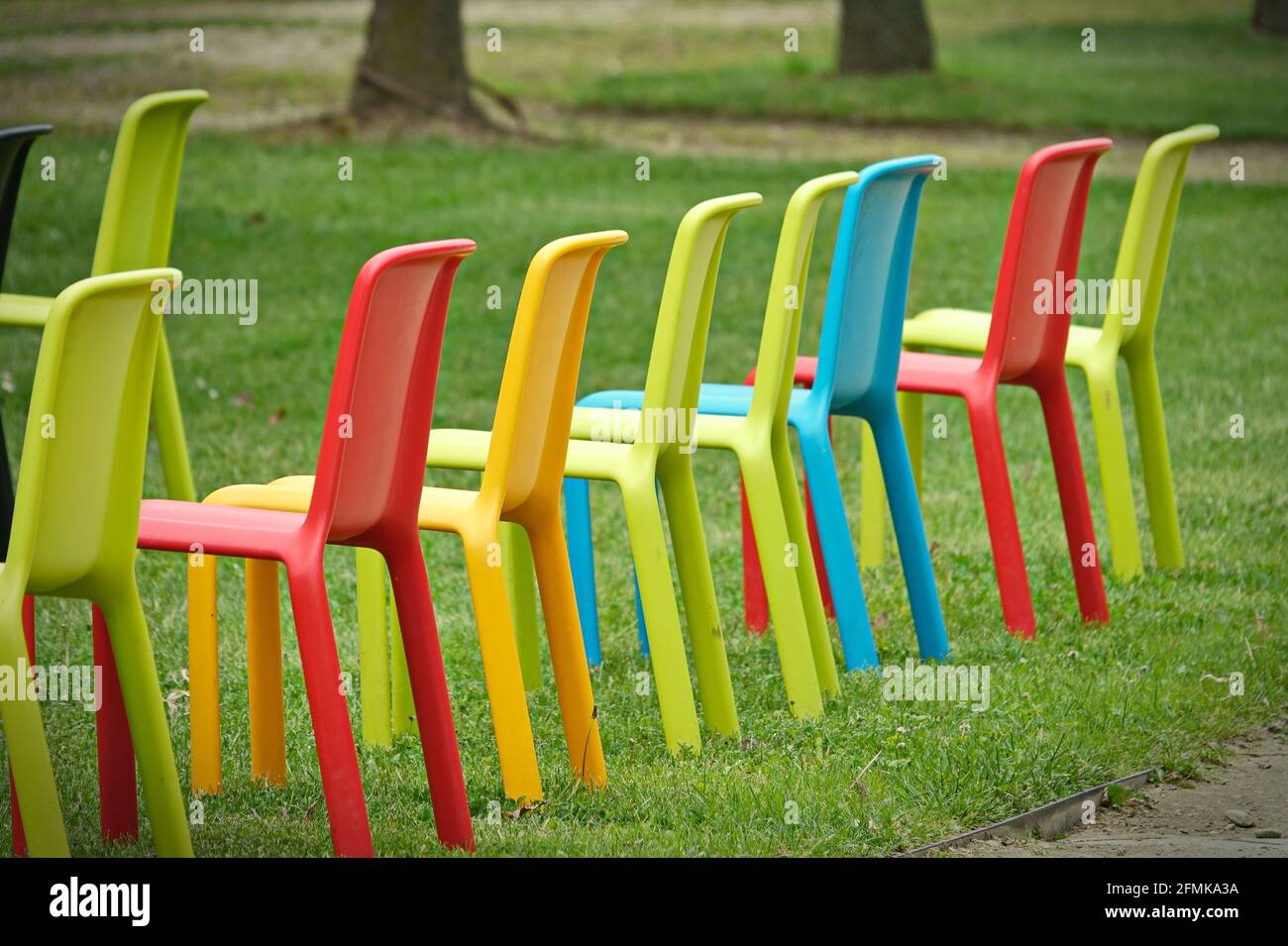Row of multicolored empty chairs for an outdoor event Stock Photo