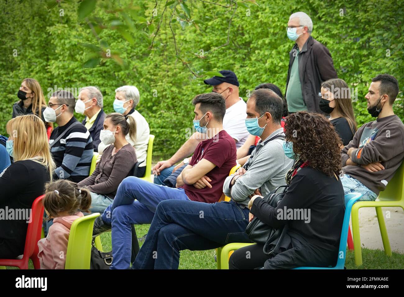 Audience wearing covid masks at first play in an outdoor park for post-pandemic reopening. Milan, Italy - May 2021 Stock Photo