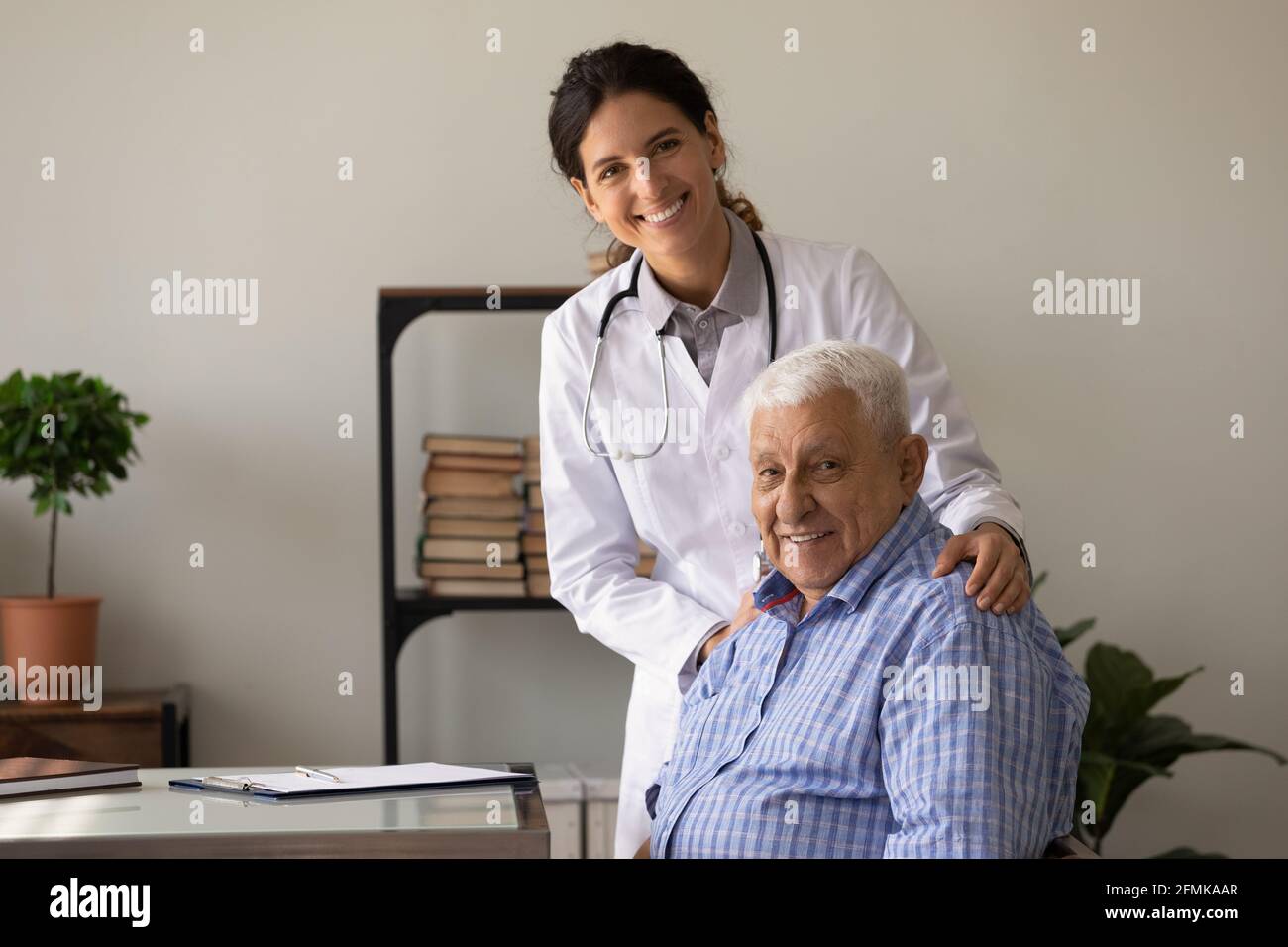 Portrait of smiling doc and retired patient in doctor office Stock Photo