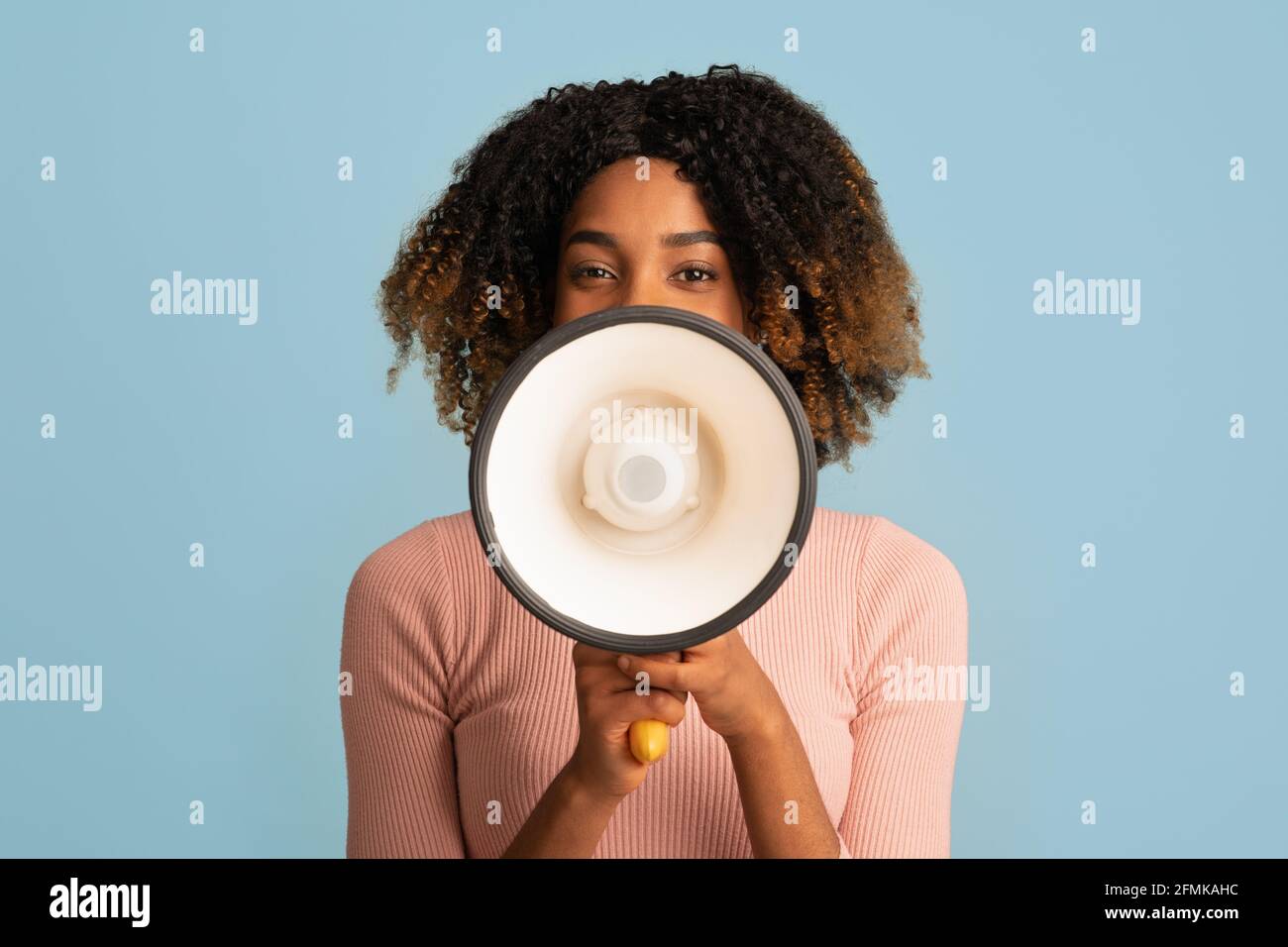 Portrait Of Happy Cheerful Black Woman With Loudspeaker In Hands Sharing Information, Curly African American Female Making Announcement With Megaphone Stock Photo