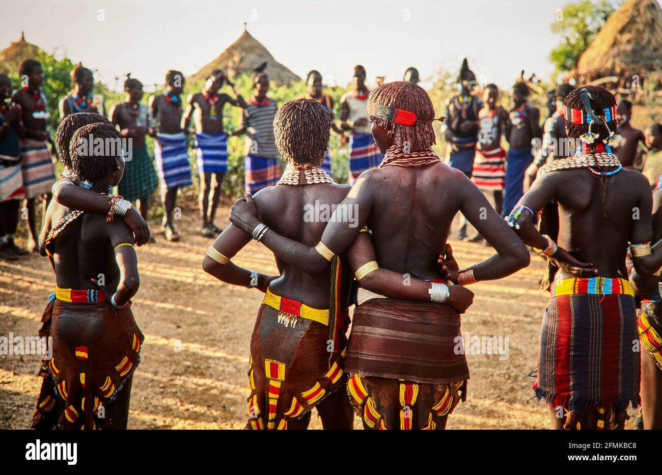 Arm in arm ready to dance. Tourist groups can attend the traditional dance of the young Hamer for a small fee for the village. Men and women are lined Stock Photo