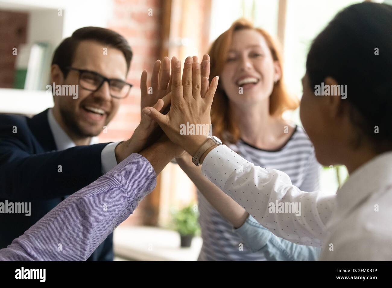 Close up diverse employees team giving high five, celebrating success ...