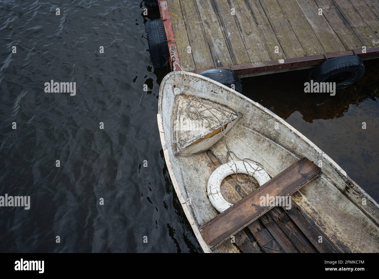 Old fishing boat parked near wooden pier Stock Photo - Alamy