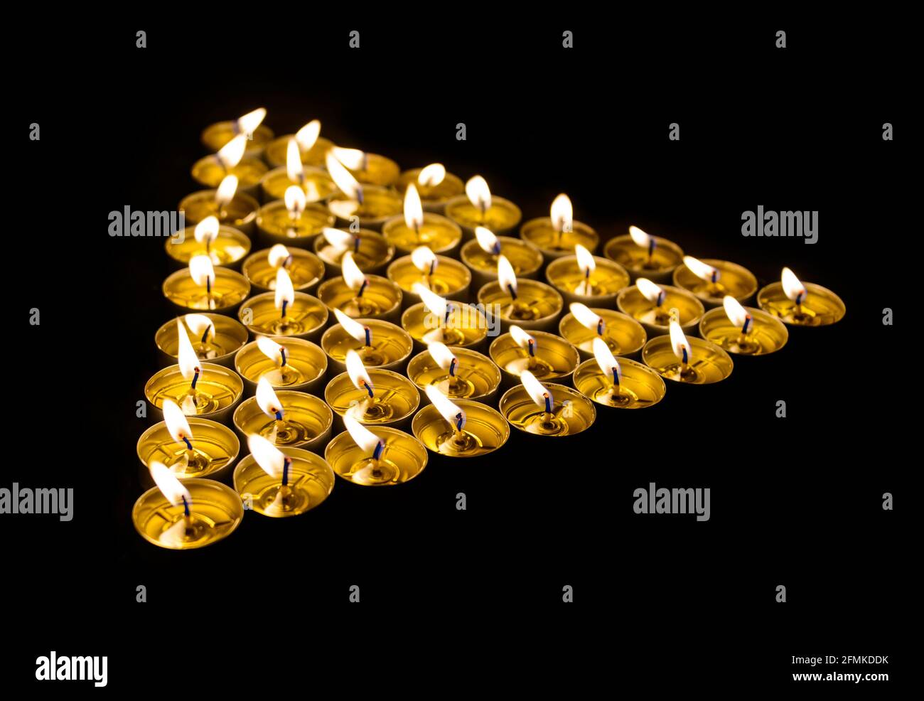 Triangle made of burning candles at night Stock Photo Alamy