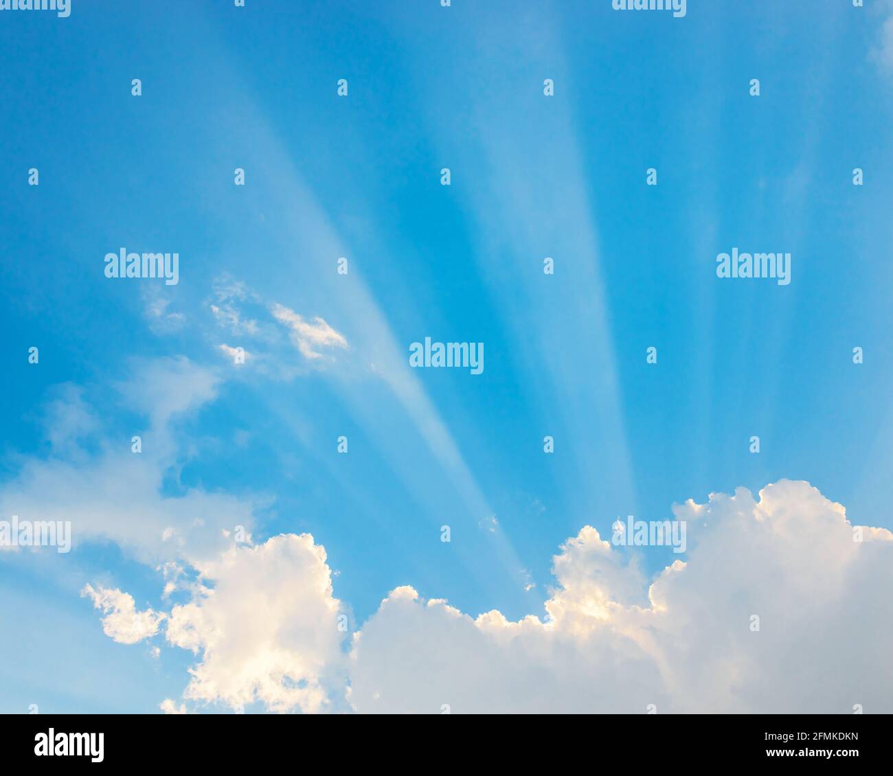 Sunrays passing through clouds and blue sky Stock Photo - Alamy