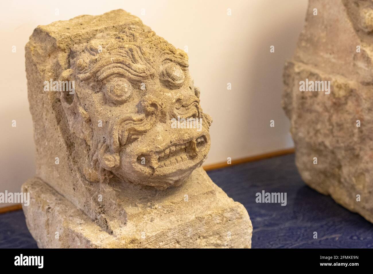 The head of the statue from the facade of the building. A free-standing, well-preserved monster's head from the eaves of an old house. Stock Photo