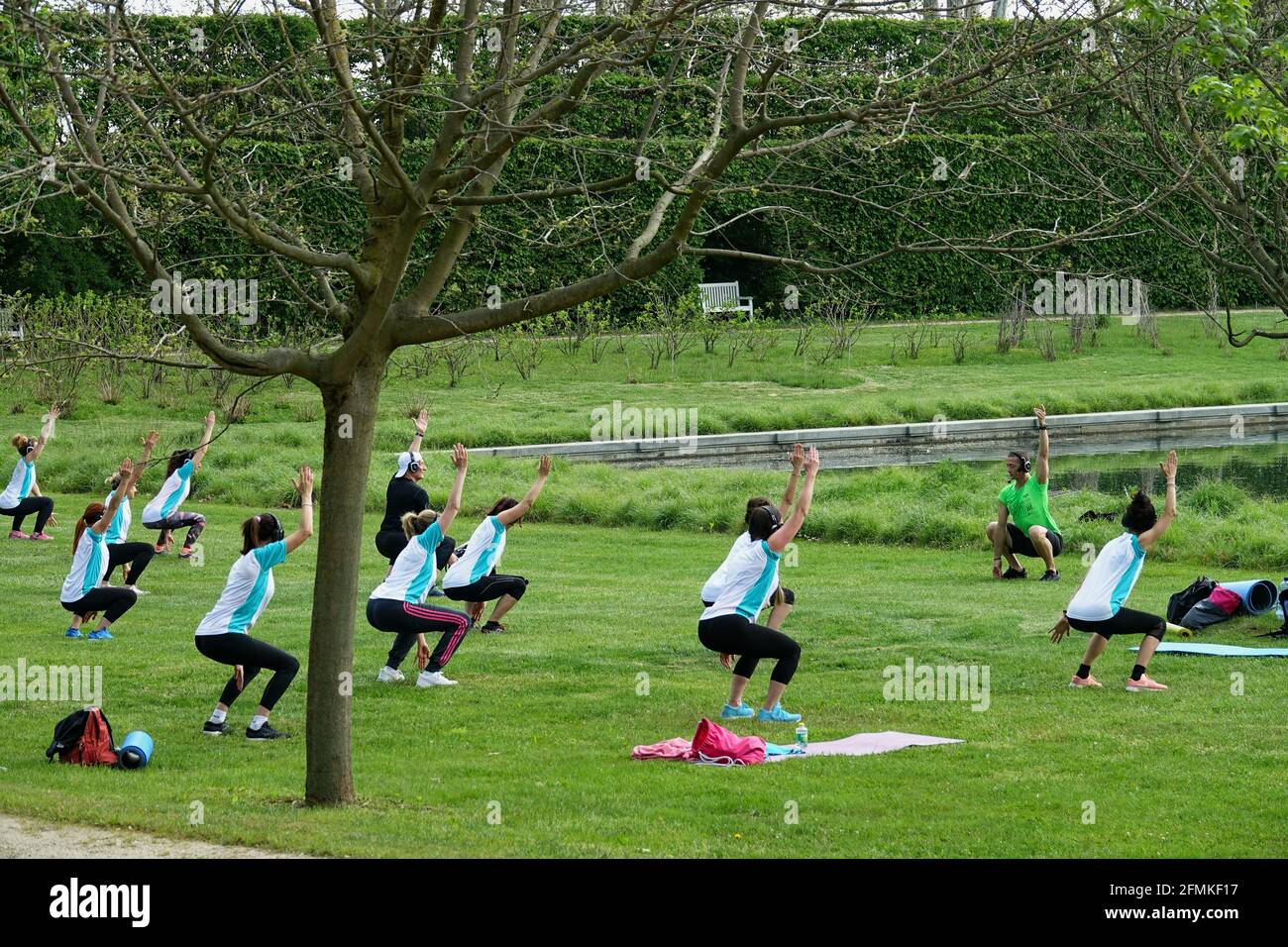 Training outdoors. Open air. People doing group exercise in the park keeping distance from each other. Social distancing after covid-19 coronavirus qu Stock Photo