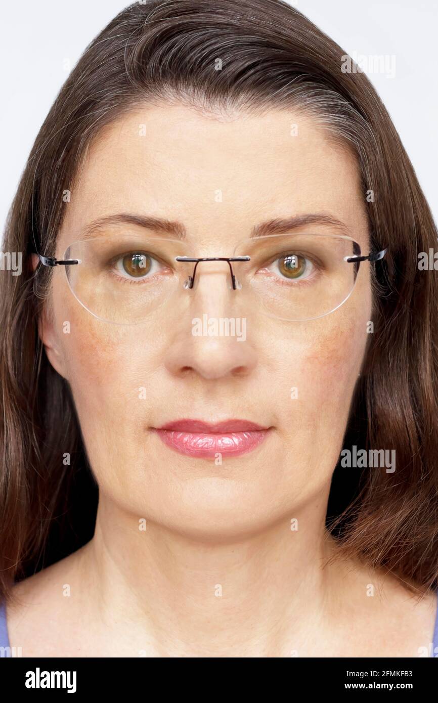 Biometric passport photo of a middle aged woman with long dark hair and  glasses, neutral light background Stock Photo - Alamy
