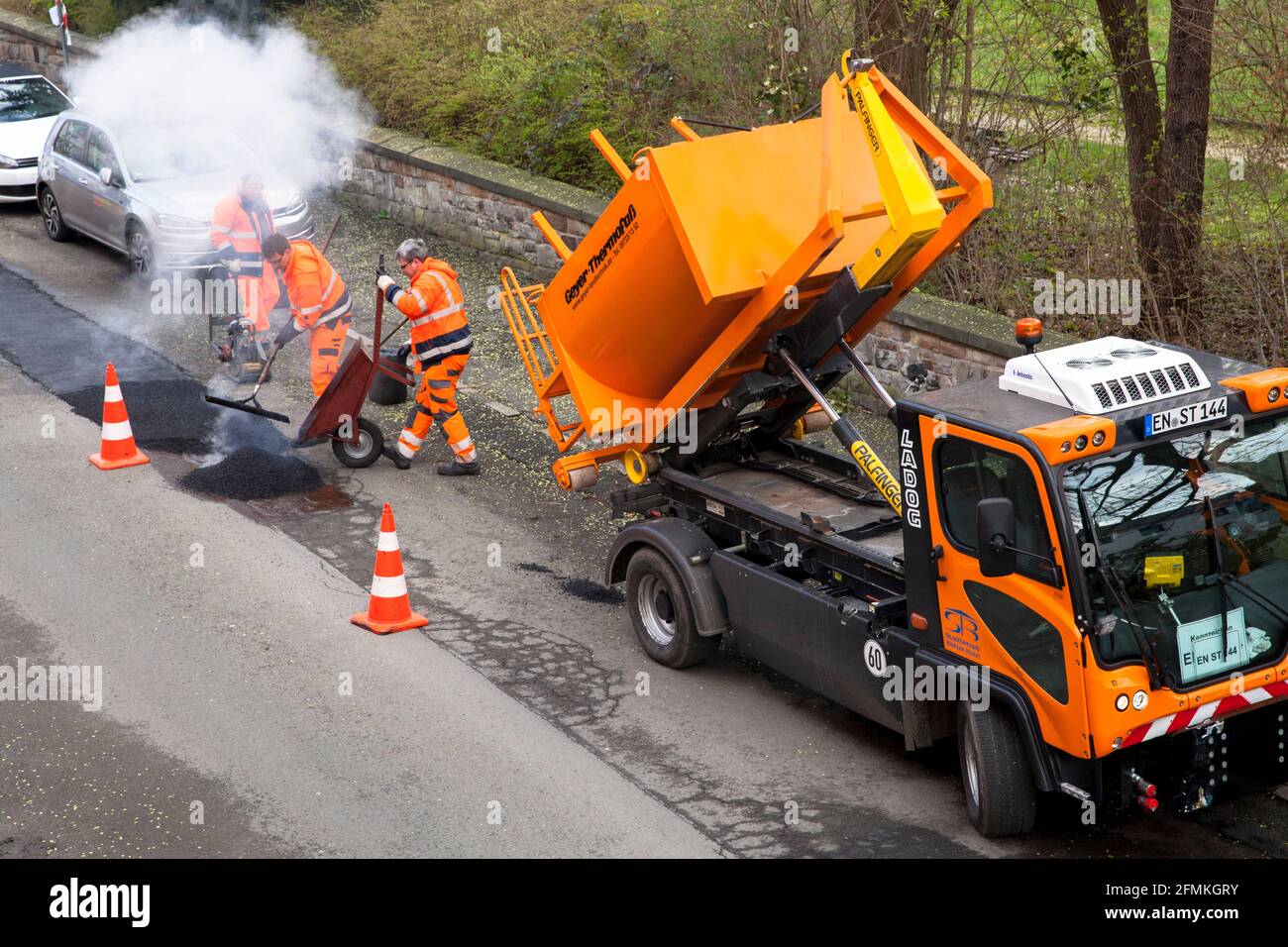 road repair works in the city of Wetter, filling of roadway damages with tar, North Rhine-Westphalia, Germany.   Strassenausbesserungsarbeiten in Wett Stock Photo