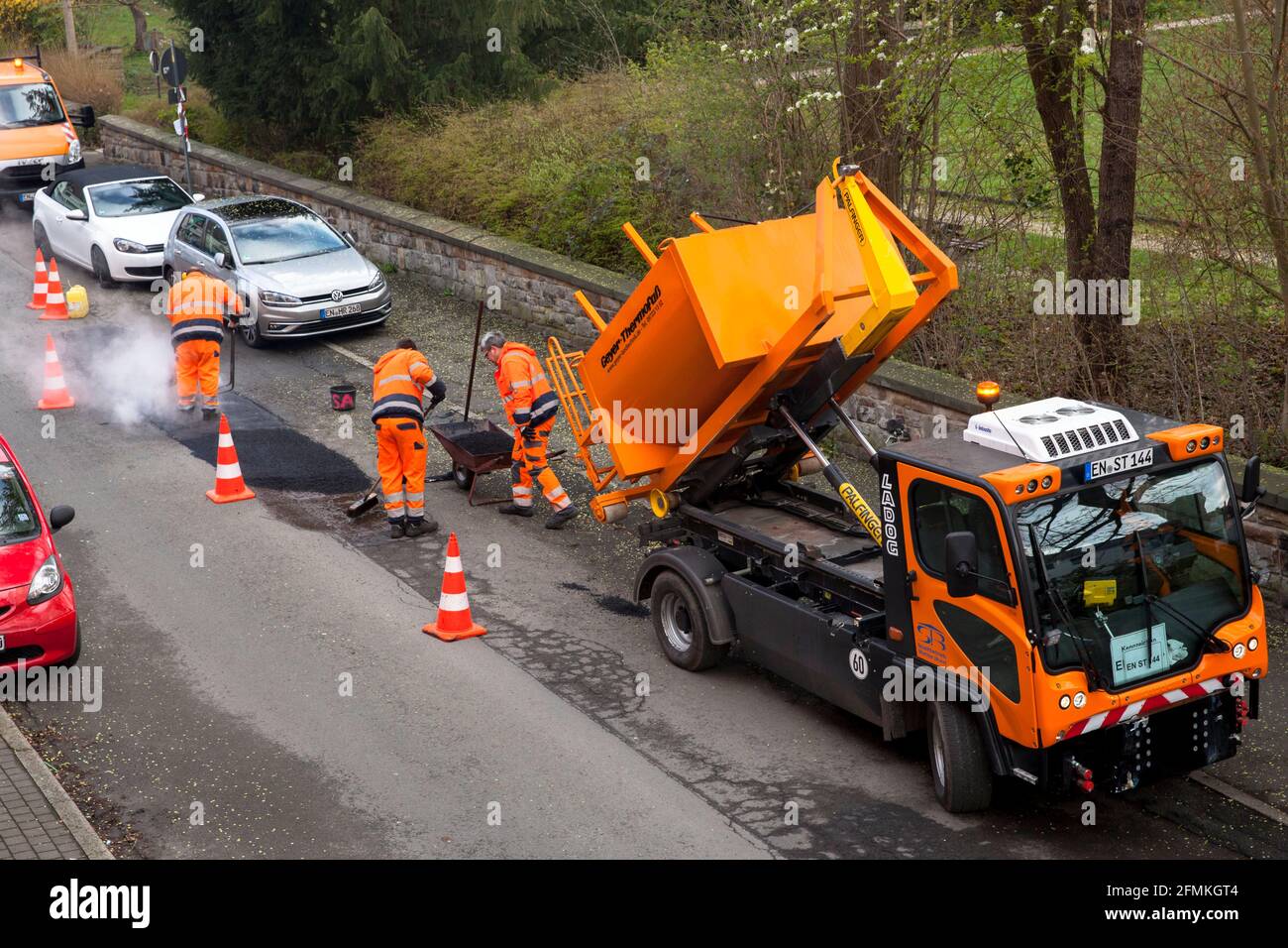 road repair works in the city of Wetter, filling of roadway damages with tar, North Rhine-Westphalia, Germany.   Strassenausbesserungsarbeiten in Wett Stock Photo