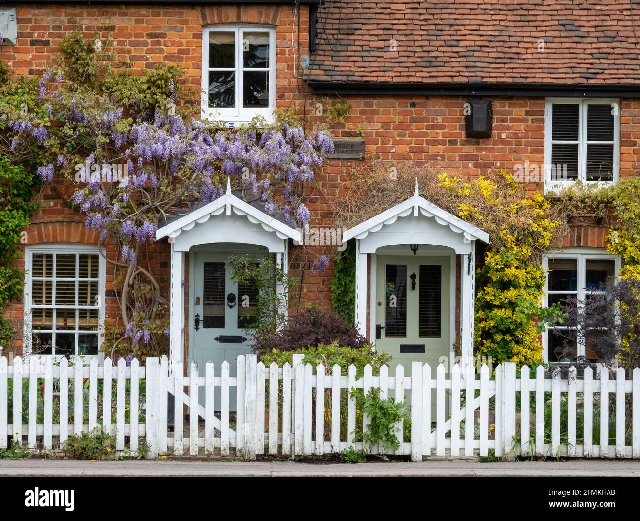 Church Cottages on The Ridgeway in Mill Hill, northwest London UK. Characterful cottages are covered in purple flowered wisteria in spring. Stock Photo