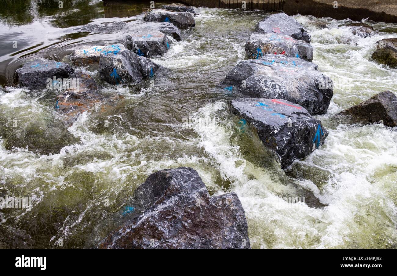 River flowing over man made fish ladder boulders Stock Photo