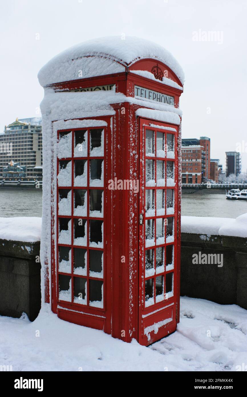 Snow settled on a traditional British red telephone box at the southern side of Tower Bridge, London, UK. February 2009 Stock Photo