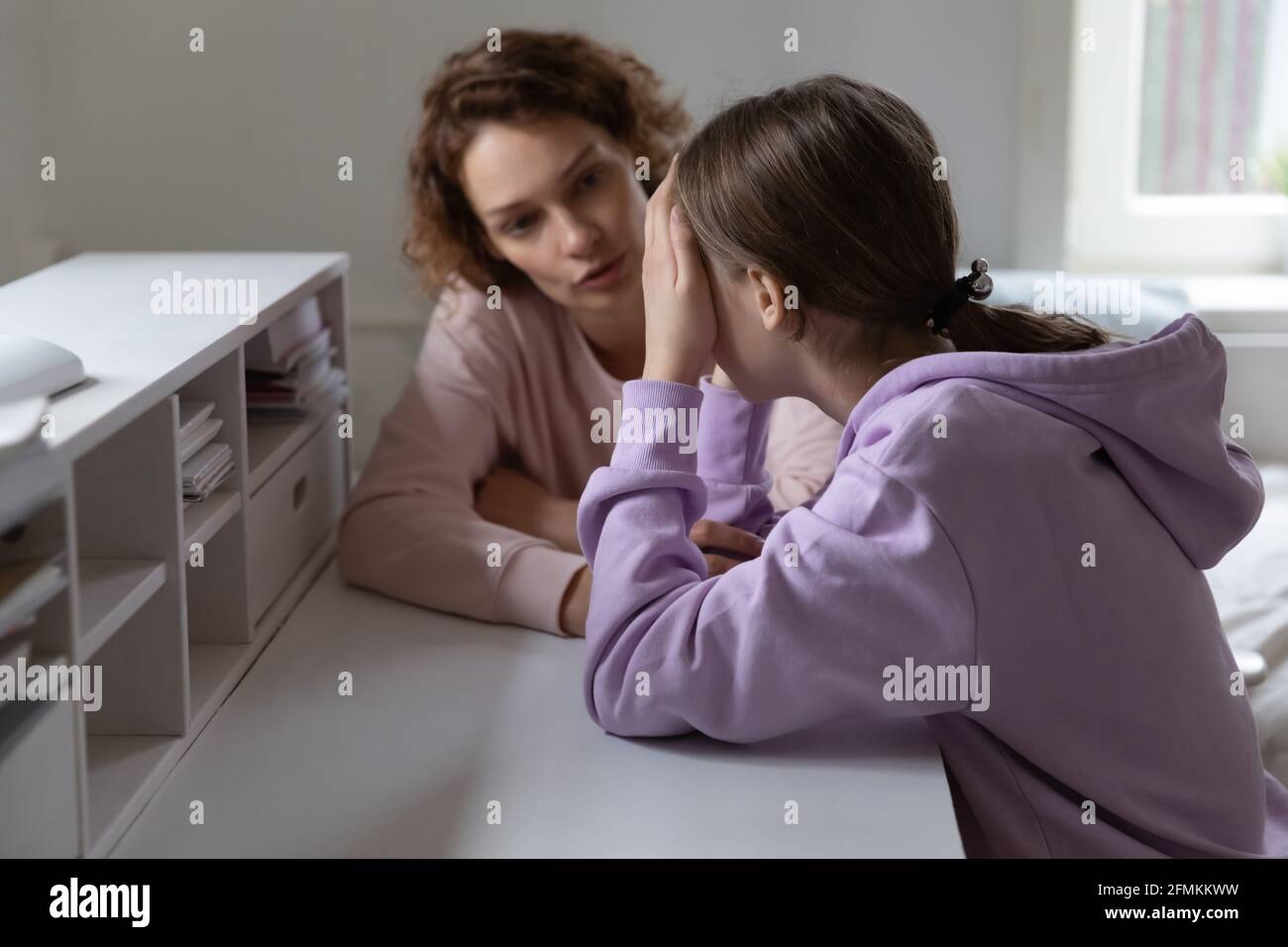 Caring mother talking to stressed adolescent daughter. Stock Photo