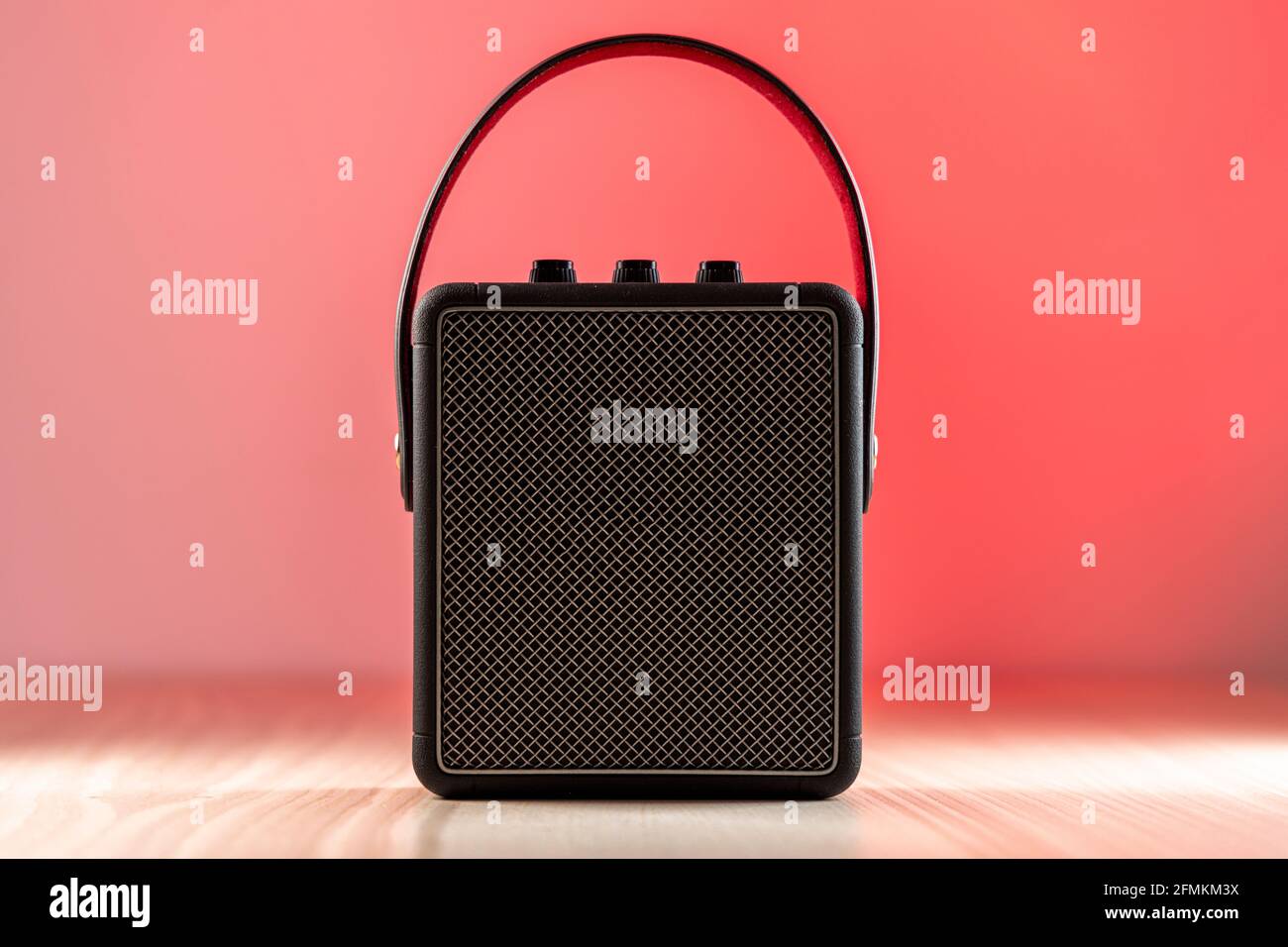 Black modern bluetooth loudspeaker on a reddish background Stock Photo