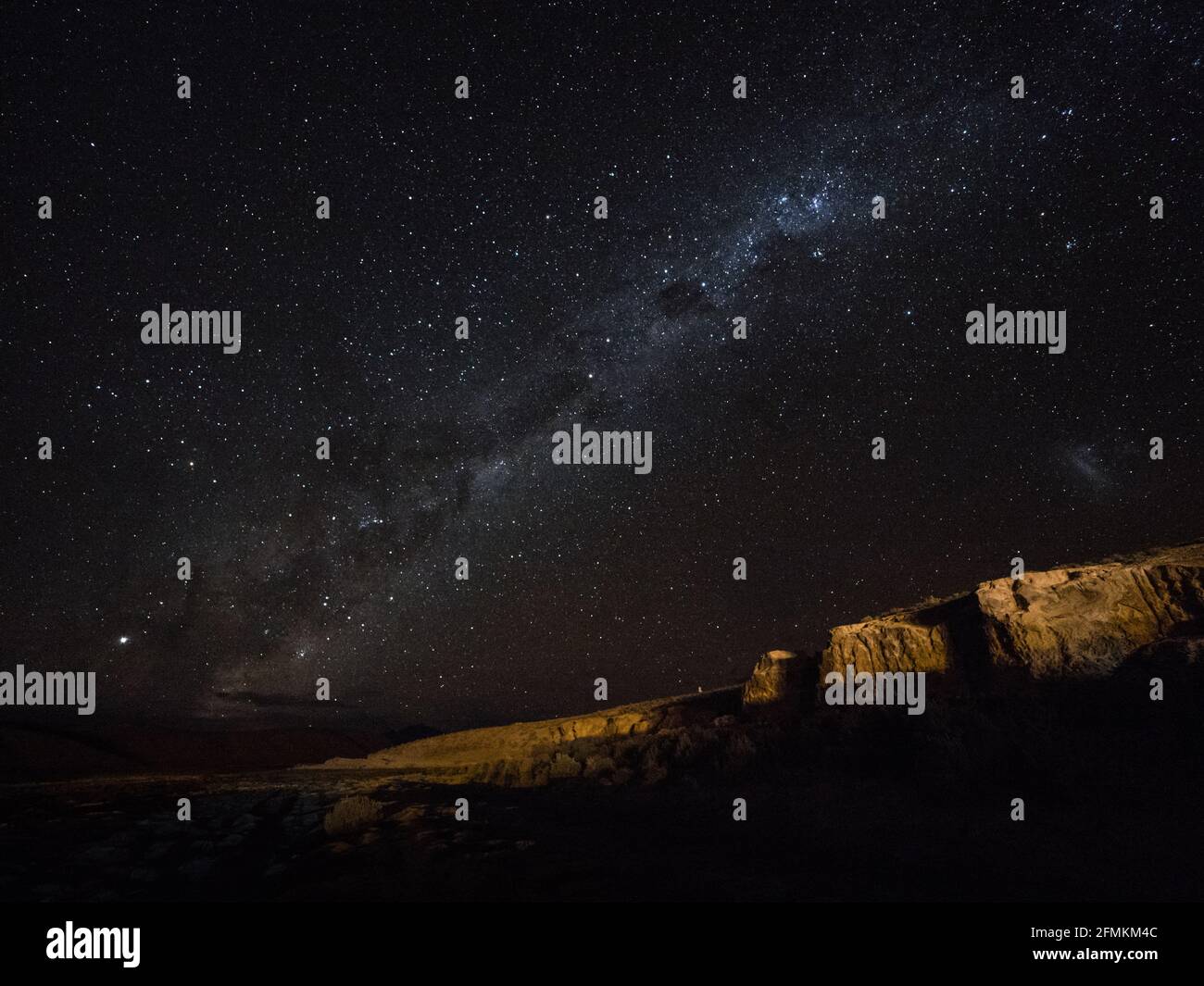 Panorama view of milkyway stars in dark night sky above cliff rock formation in Uyuni Sur Lipez Potosi Bolivia South America Stock Photo
