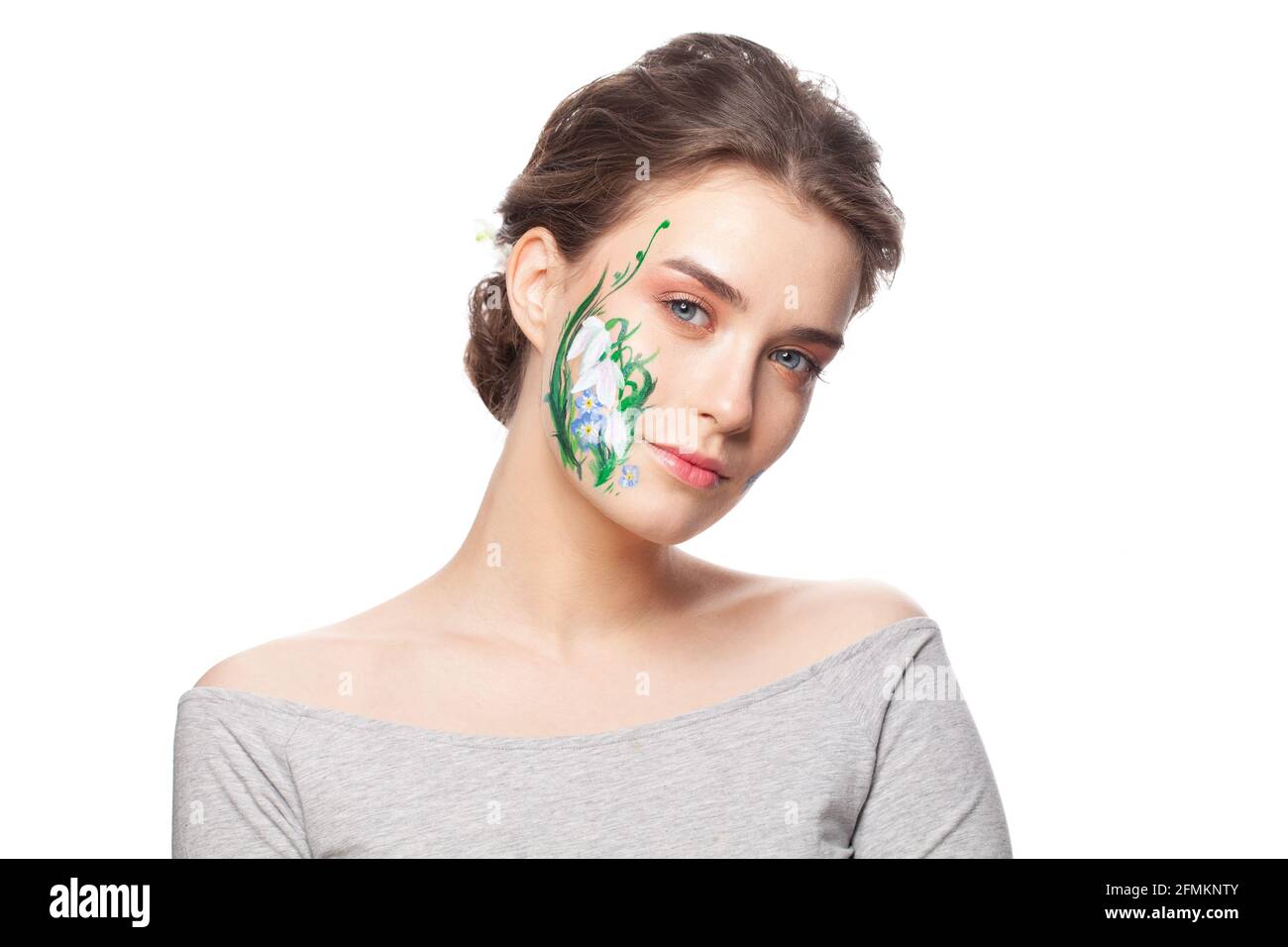 Cute woman with painted spring flowers on her face isolated on white background Stock Photo