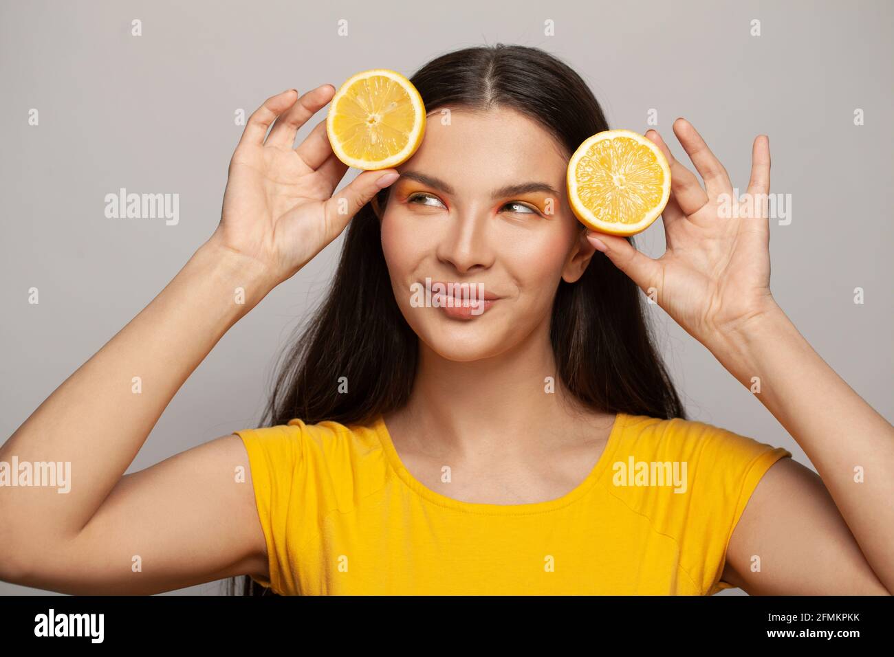 Happy pretty healthy woman with clear skin and straight hair holding lemon  fruits on white background. Diet, skincare and facial treatment concept  Stock Photo - Alamy