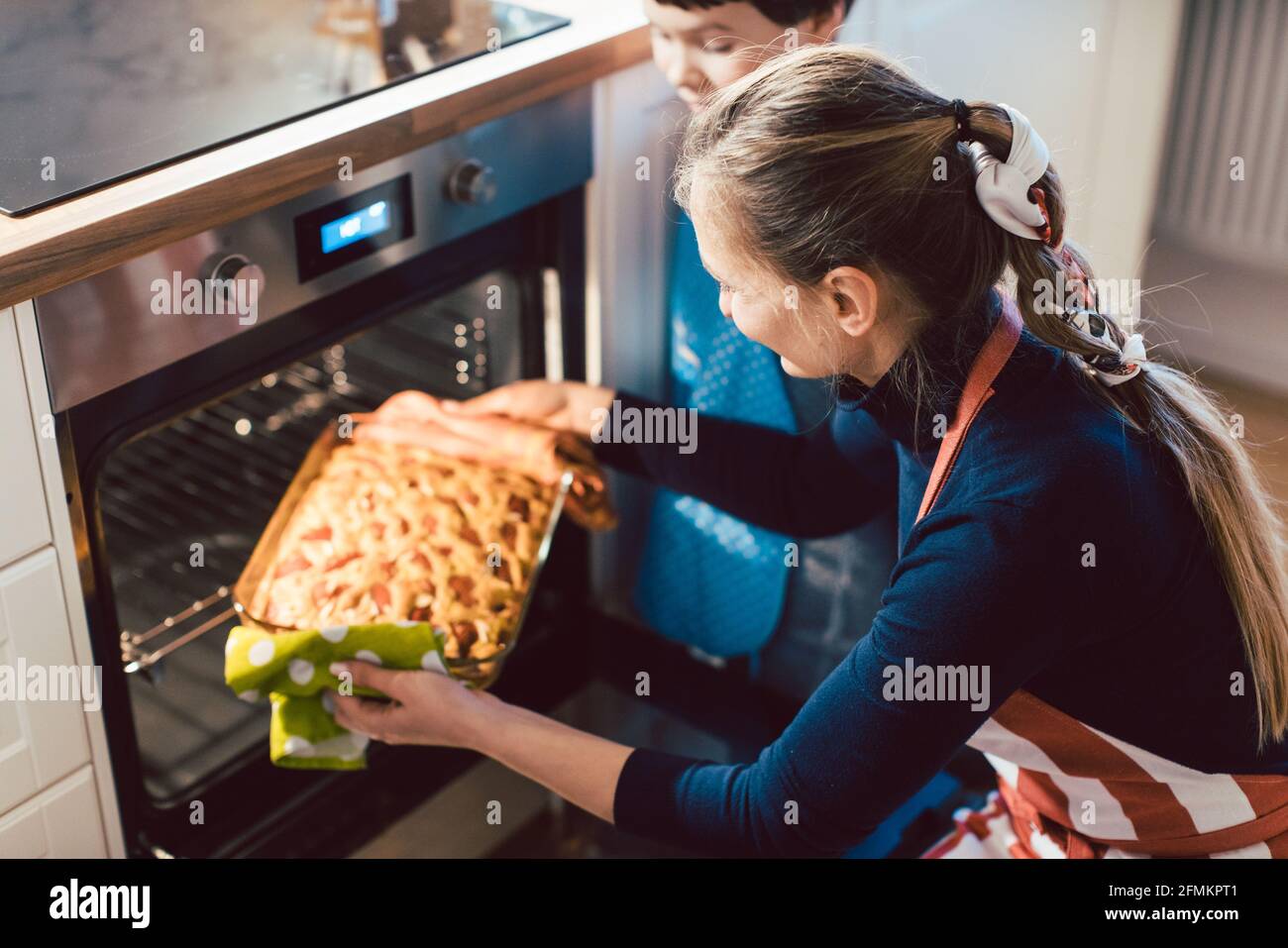 Mother and son baking pie in oven Stock Photo