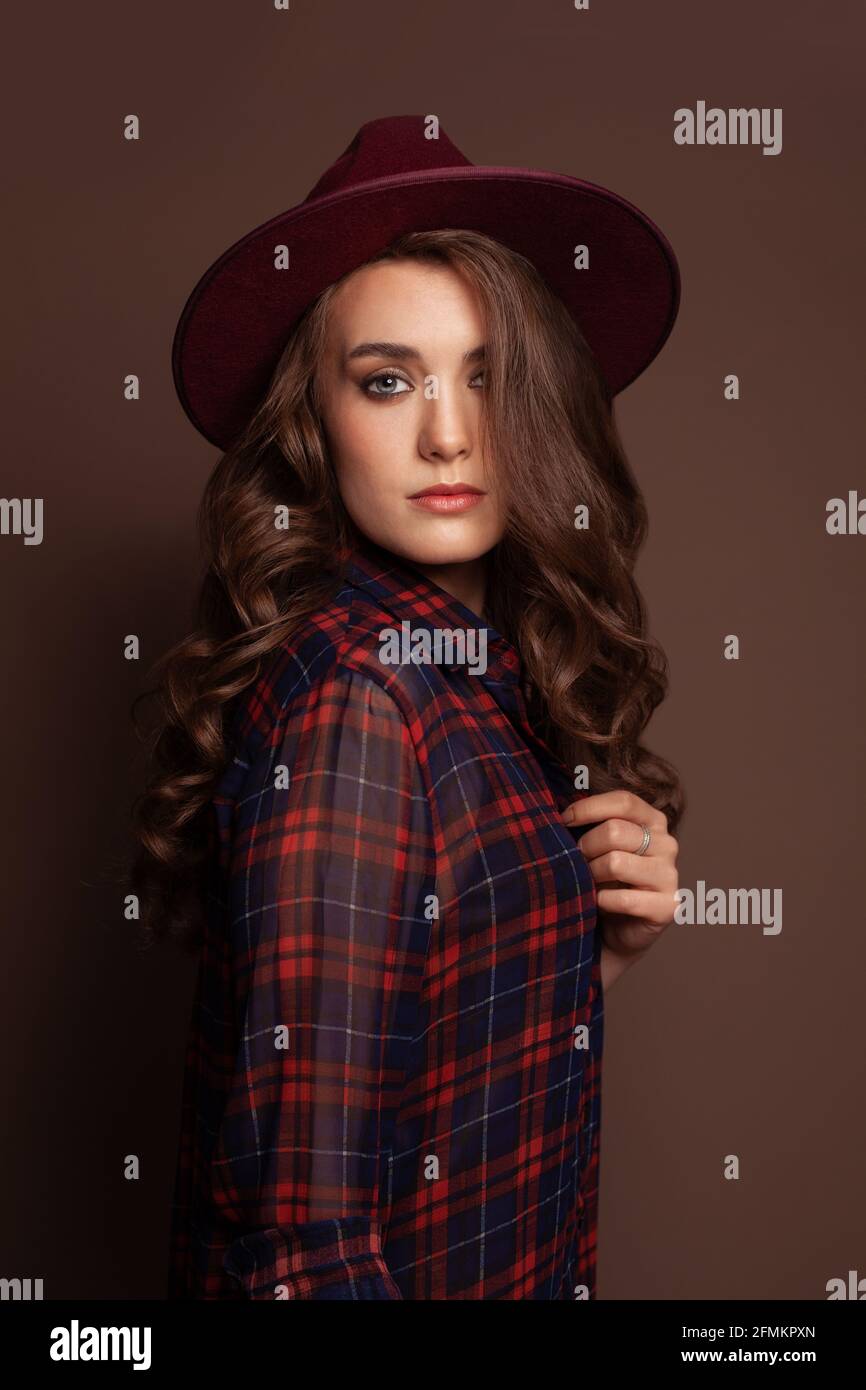 Casual woman wearing fedora hat on brown background Stock Photo Alamy