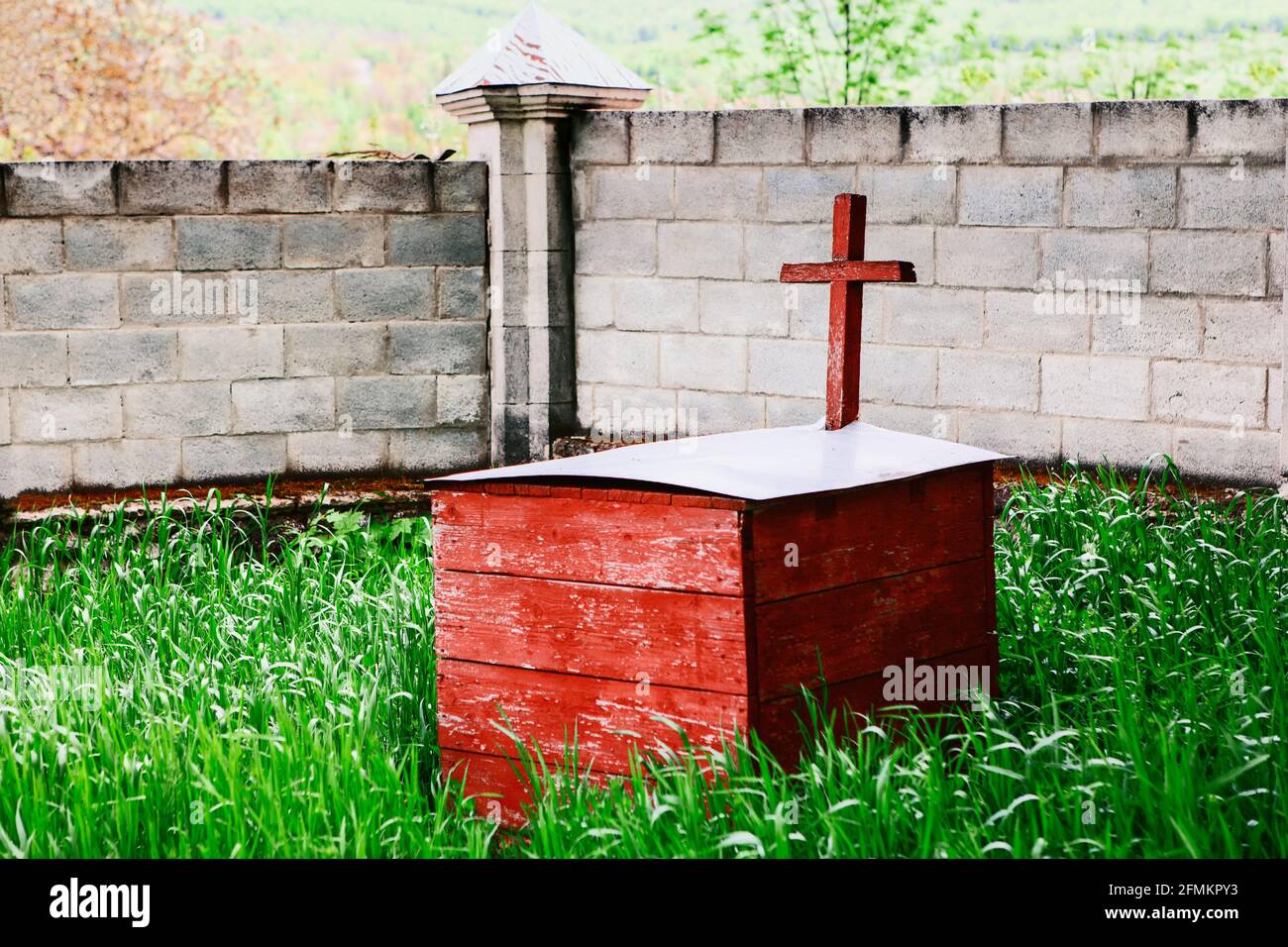 Wooden box on the graveyard . Religious cross painted in red Stock Photo