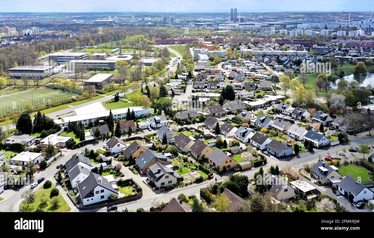 Aerial view of a housing estate on the outskirts of the city of Wolfsburg in Germany with a school in the background and factories on the horizon. Stock Photo