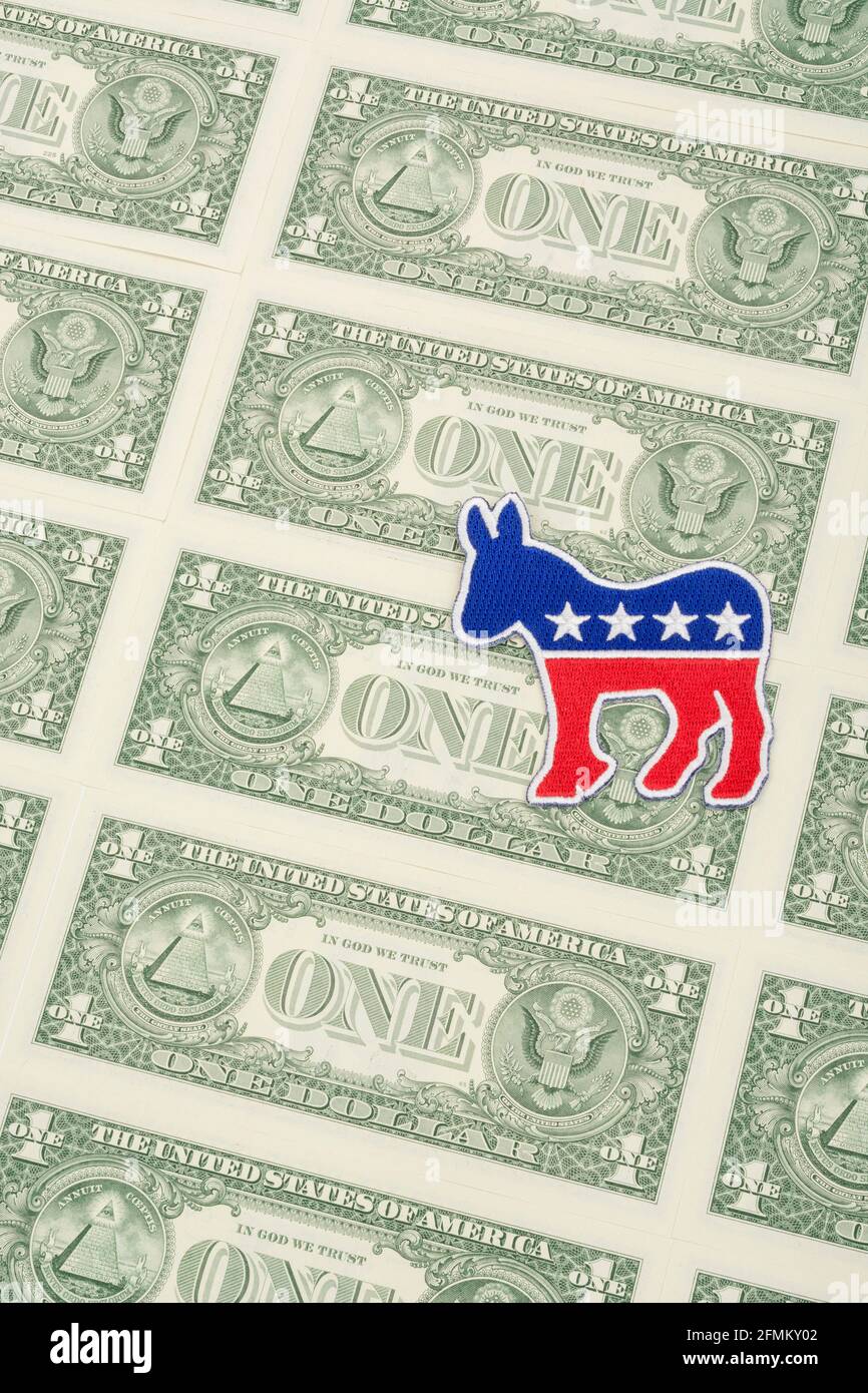 Democrat donkey logo patch badge & US $1 dollar banknotes. For US political fundraising & DNC Democrat campaign funds, Biden debt pile, small $ donors Stock Photo