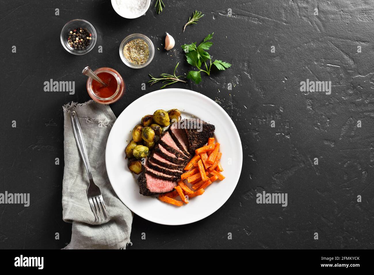 Grilled beef steak with brussels sprouts and sweet potatoes over black