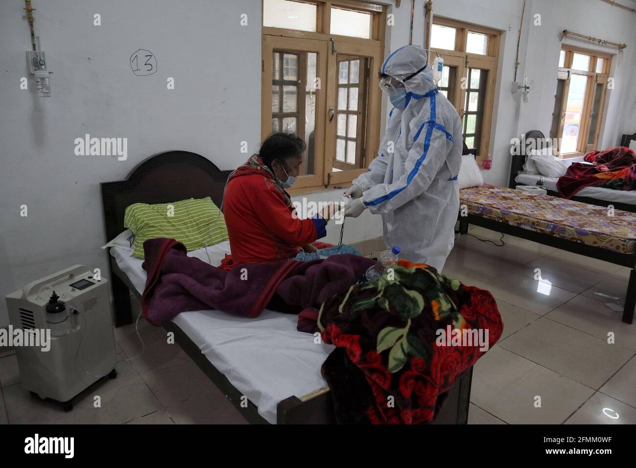 May 8, 2021: A Health worker examins a Covid-19 patient at a temporary Covid-19 hospital in Srinagar, Indian Administered Kashmir on 08 May 2021. A Local NGO Athrout has converted Hajj house into a 100-bedded Covid centre as the space in hospitals is filling up fast Credit: Muzamil Mattoo/IMAGESLIVE/ZUMA Wire/Alamy Live News Stock Photo