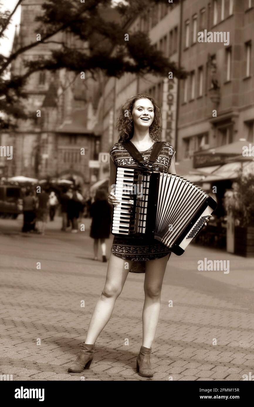 Nürnberg, in der Innenstadt oder City spielt eine bezaubernd schöne jung Frau auf  ihren Akkordeon, oder auch Ziehharmonika, Nuernberg, Franken, Bayer Stock Photo