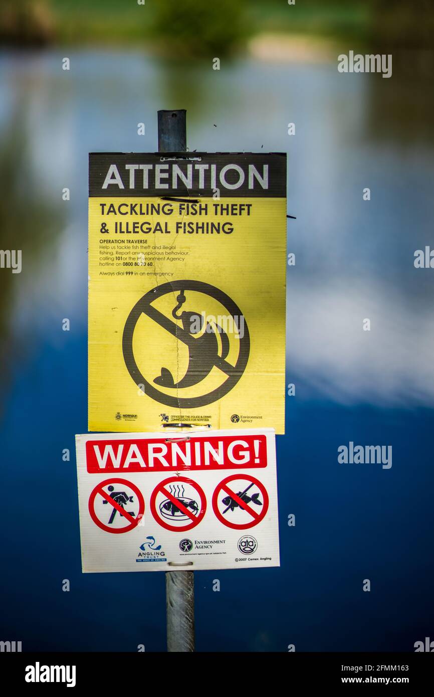 Illegal Fishing Warning Sign at a fishing lake in the UK. Fishing Warning Signs about Tackling Fish Theft & Illegal Fishing. Stock Photo