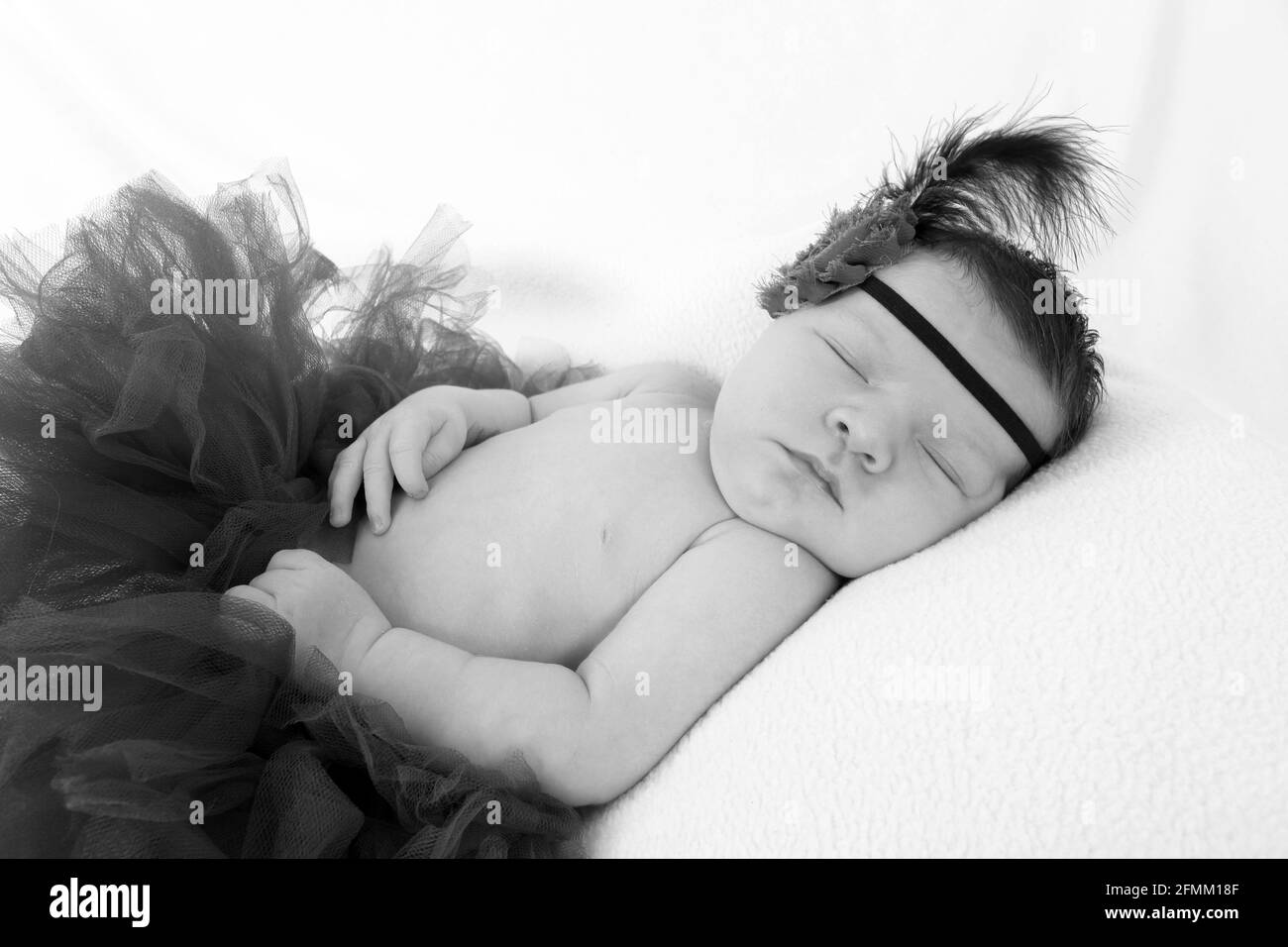 1 week old baby girl sleeping on a blanket in the nursery, home from
