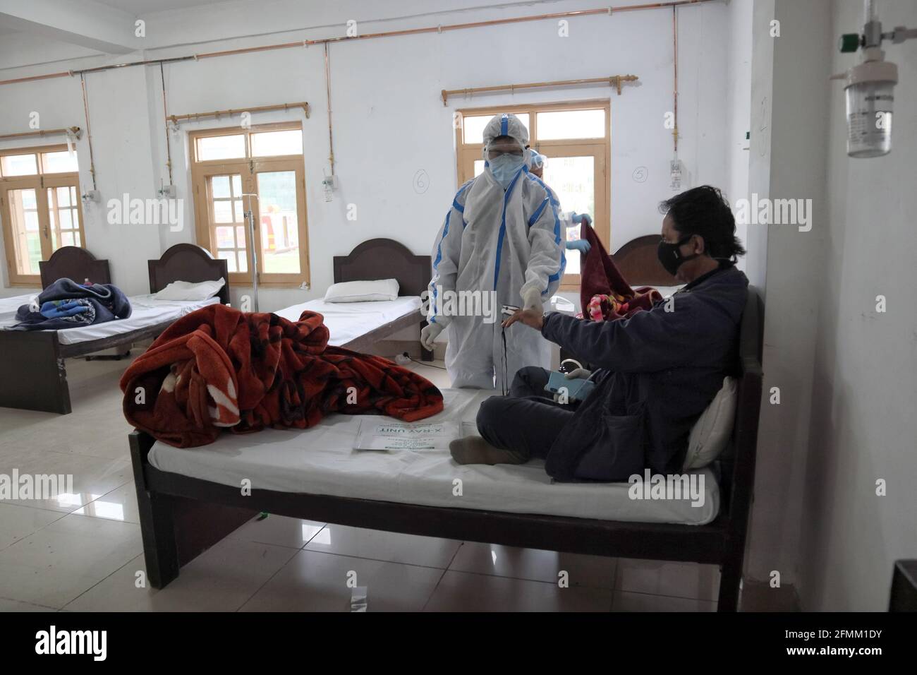May 8, 2021: A Health worker examins a Covid-19 patient at a temporary Covid-19 hospital in Srinagar, Indian Administered Kashmir on 08 May 2021. A Local NGO Athrout has converted Hajj house into a 100-bedded Covid centre as the space in hospitals is filling up fast Credit: Muzamil Mattoo/IMAGESLIVE/ZUMA Wire/Alamy Live News Stock Photo