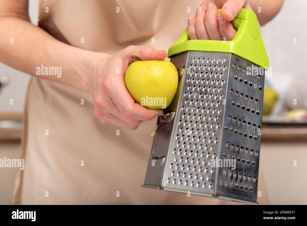 Chef grates an apple to make an apple pie Stock Photo