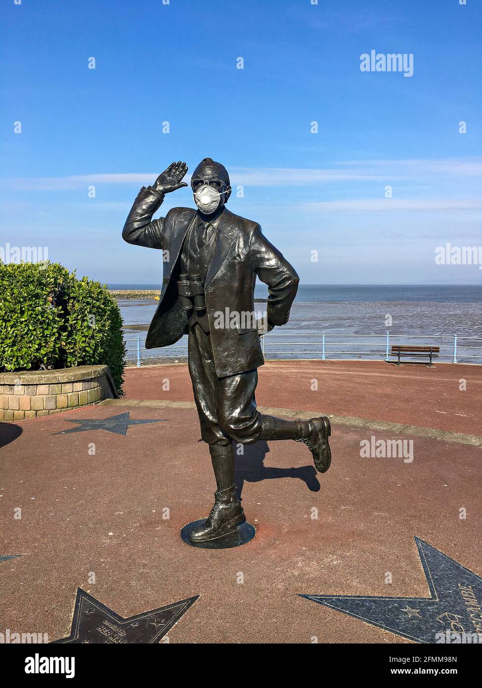 Statue on the seafront in Morecambe of the comedian Eric Morecambe wearing a protective face mask Stock Photo