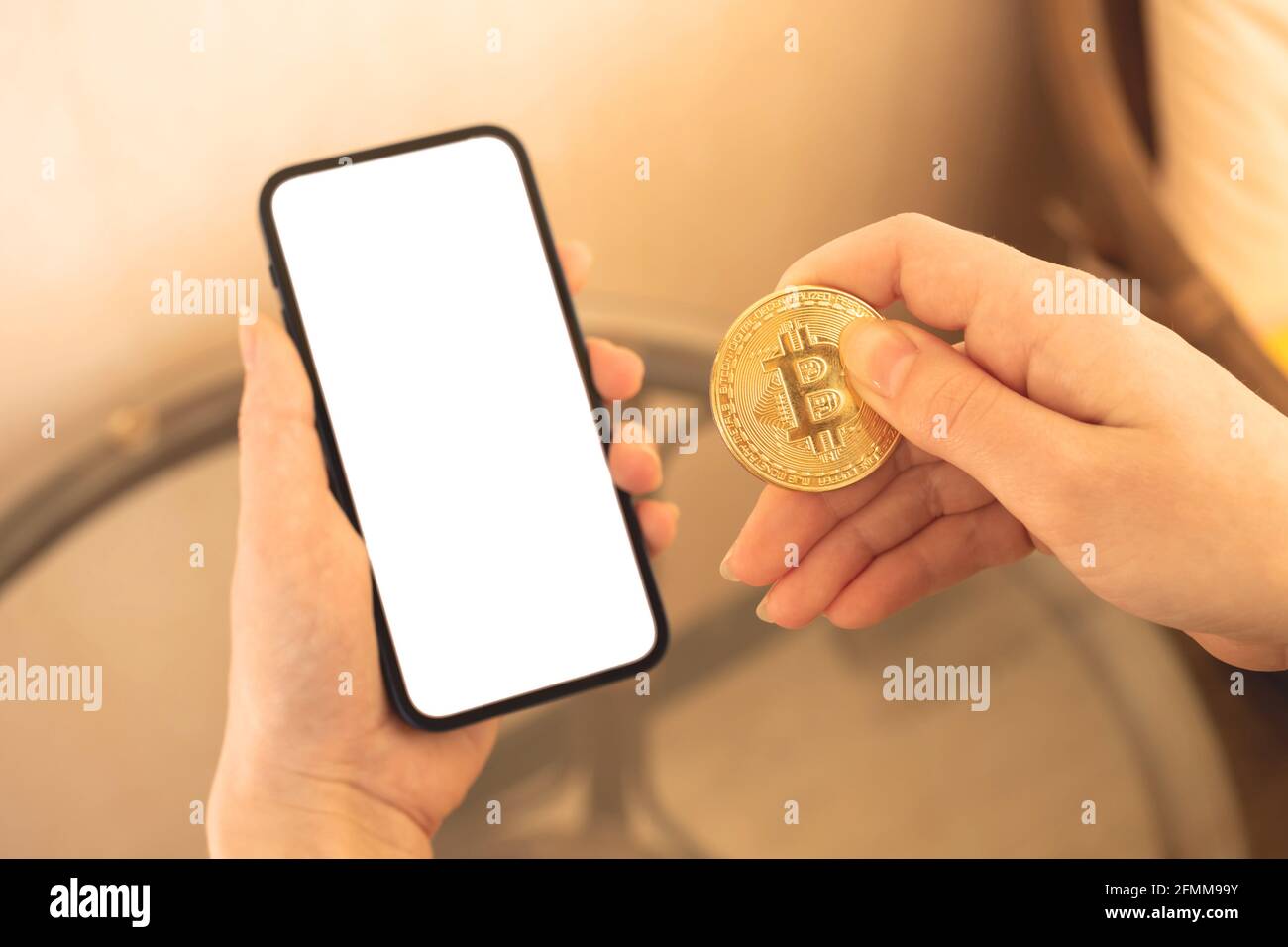 Payments by a crypto currency mockup, mobile phone with blank white screen  and woman hand with golden bitcoin coin, copy space Stock Photo - Alamy