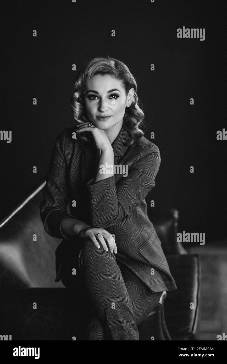 Portrait of a confident beautiful business woman in a suit on a dark background. The concept of gender equality. Strong independent woman. Soft select Stock Photo