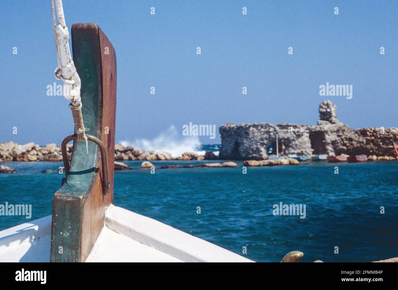 Scanned image of sbow of boat leaving Naoussa, Paros, In soft focus the Venitian Castle can be seen Stock Photo