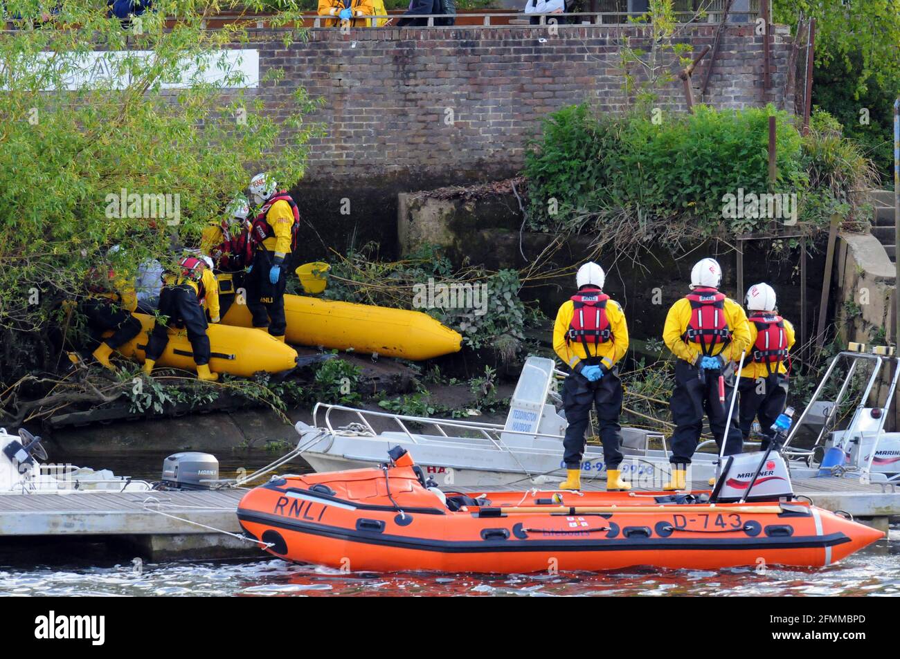 London, UK, 10 May 2021 RnLI members stand at attention as the young Minke whale is euthanized. Minke whale at Teddington Lock in the Thames. Credit: JOHNNY ARMSTEAD/Alamy Live News Stock Photo